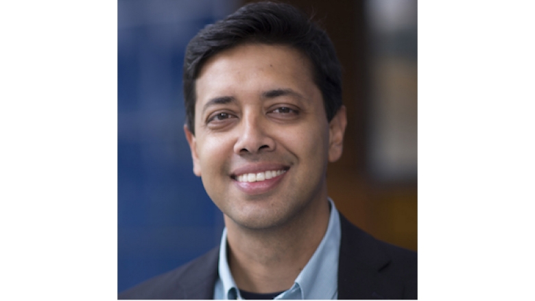 Male with black hair, wearing dark blue blazer and light blue blouse