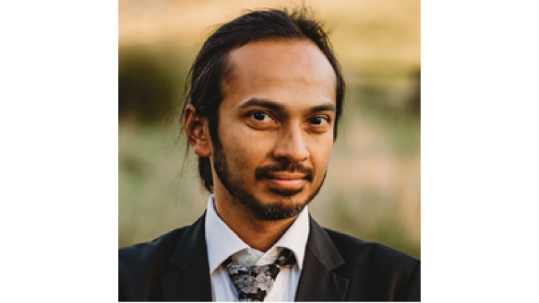 Male with black long pony tail, wearing brown blazer and white blouse