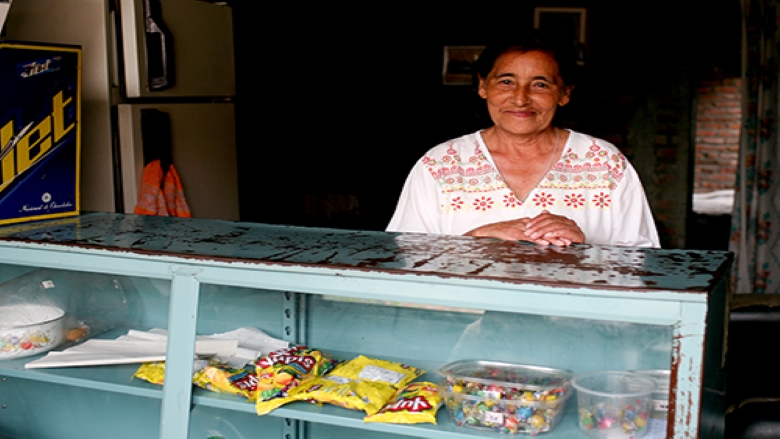 A woman standing behind a snack stand