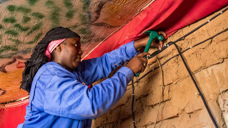 Adaouia Birema works at installing electricity at a client's house in Chad. Photo: Vincent Tremeau/World Bank