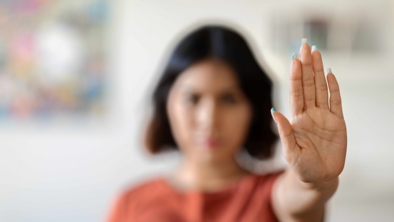 Woman with hand raised to camera