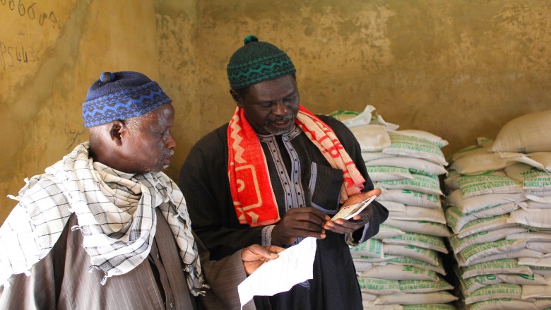 Two men looking at a document together in a grain storage area