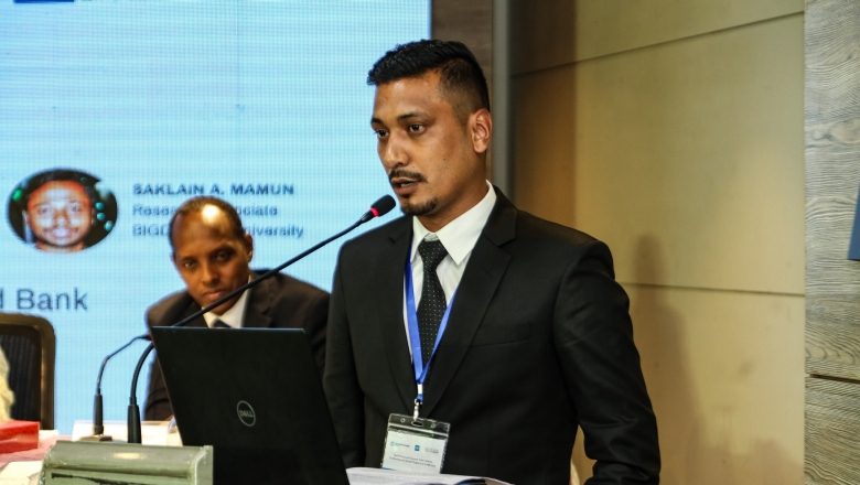 Male speaker on the podium wearing black suit