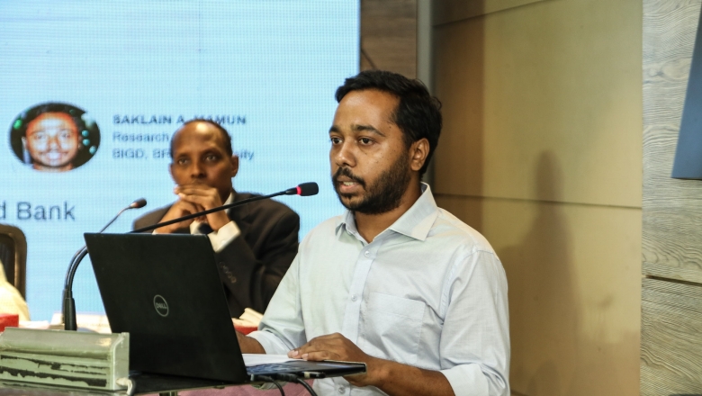 Male speaker on the podium wearing white blouse