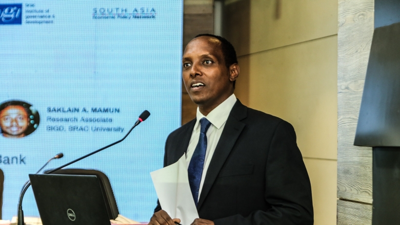 Male speaker on the podium wearing blue suit