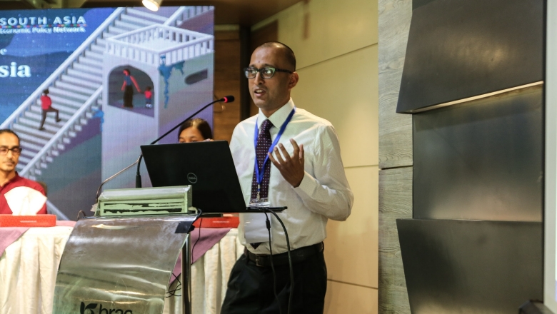 Male speaker on the podium wearing white blouse