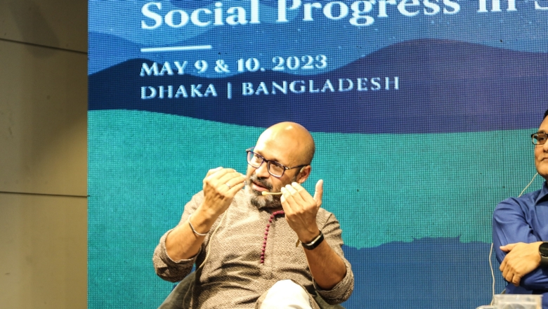 Male speaker on stage wearing traditional Bangladeshi clothes