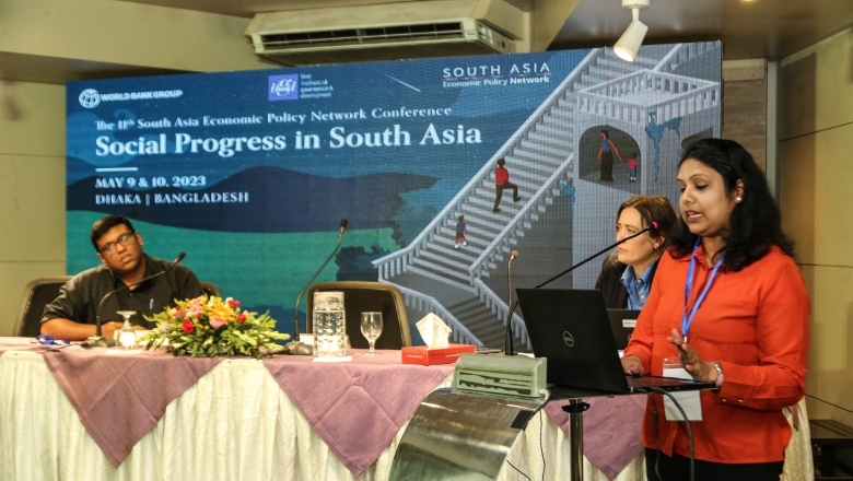 Female speaker on the podium wearing orange blouse