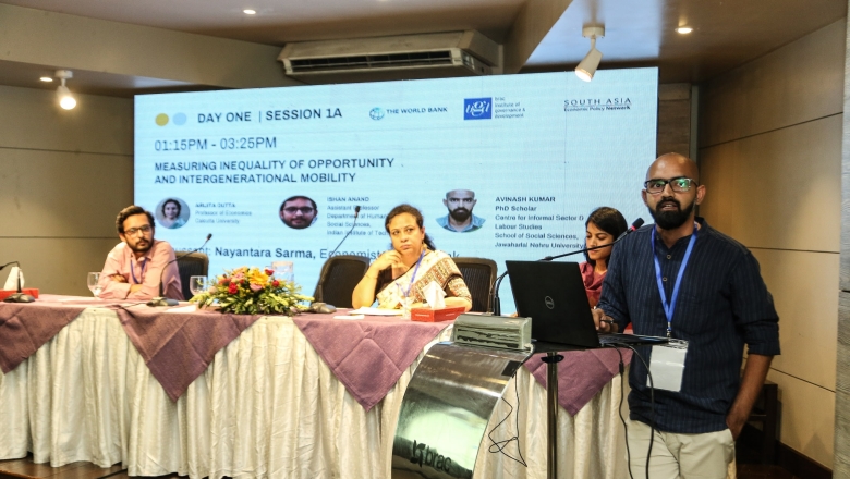 Female speaker on the podium wearing blouse and eyeglasses