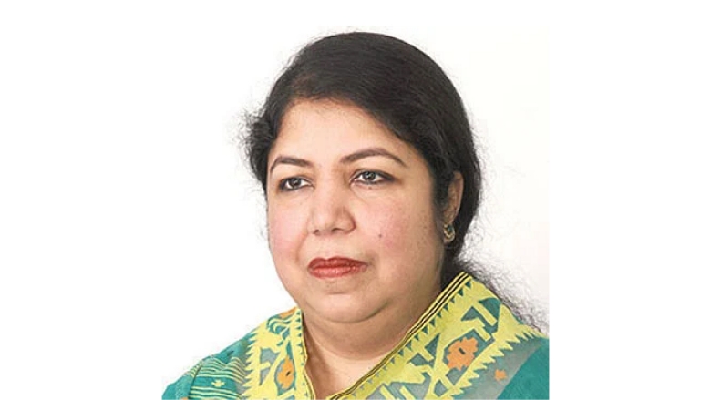 Female with dark black hair wearing green pattern blouse