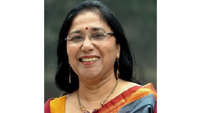 Female with short black hair wearing eye glasses and traditional colorful saree