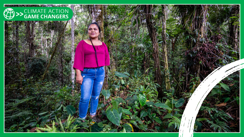 Iliana Jimenez, Community Leader and Forest Custodian, stands in the middle of a vibrant forest in Costa Rica.