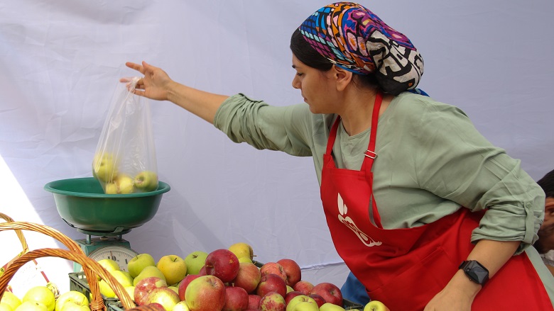 Woman weighing apples in Almaty, Kazakhstan