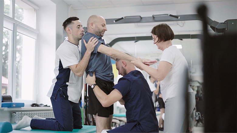 Ukrainian doctors helping in patient rehabilitation process.