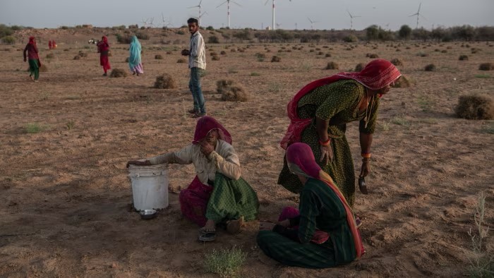 Indian female villagers drink water after finishing work harvesting