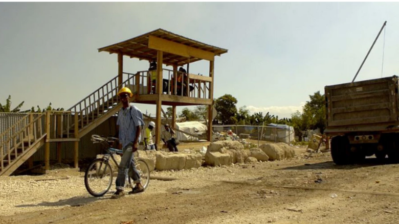 Trucks carrying the rubble from Port au Prince, Haiti into Truitier debris management site pass a checkpoint