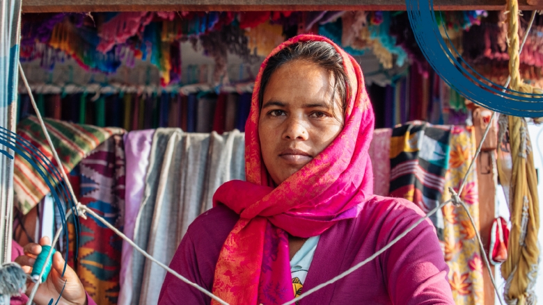 Woman weaving a carpet