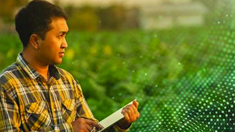 A man on a field is gathering data on his tablet