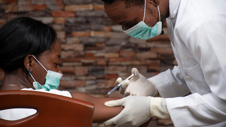 Un médecin inocule une première dose de vaccin anti-COVID dans le bras d'une jeune femme © Banque mondiale